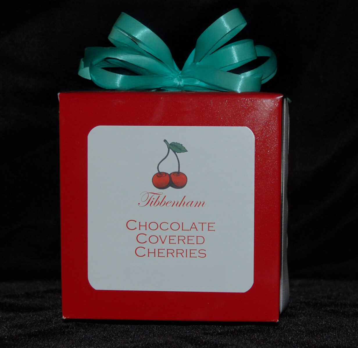 Red box with a Tibbenham Chocolates label and a green ribbon on top