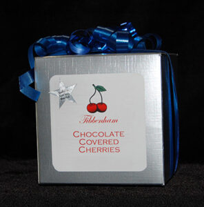 a silver box of chocolate covered cherries with a blue bow